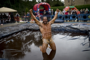 Joel Hicks celebrates winning the men's title in the 8th annual World Gravy Wrestling Championships at the Rose n Bowl Pub in Bacup, north west England on August 31, 2015. Contestants must participate in fancy dress and wrestle in a pool of Lancashire Gravy for 2 minutes whilst being scored for a variety of wrestling moves. AFP PHOTO / OLI SCARFF (Photo credit should read OLI SCARFF/AFP/Getty Images)